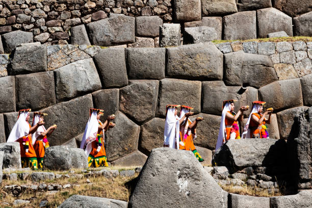 Young Women In Traditional Inca Costumes Carrying Bowl Of Corn And Potato Cusco, Peru - June 24, 2015: Young Women Dressed In Traditional Inca Costumes For Inti Raymi Ceremony Carrying Bowls Of Corn And Potato With Large Stone Blocks In Background"n inti raymi stock pictures, royalty-free photos & images