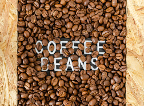istock Background with coffee beans with white inscription in the middle. 1153310482