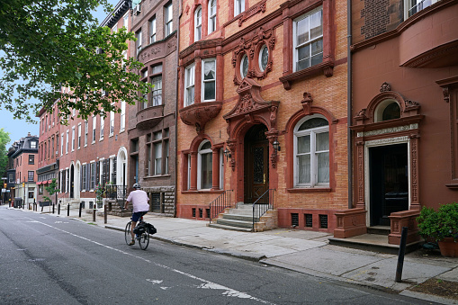 urban street with elegant old brownstone style townhouses or apartment buildings