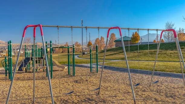 istock Panorama frame Swings climbing bars and slide at a playground viewed on a sunny day 1153314095
