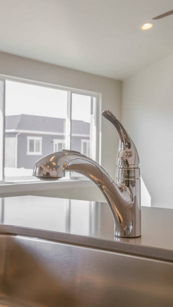 istock Vertical frame Shiny kitchen counter top with sink and faucet inside a new home 1153314096