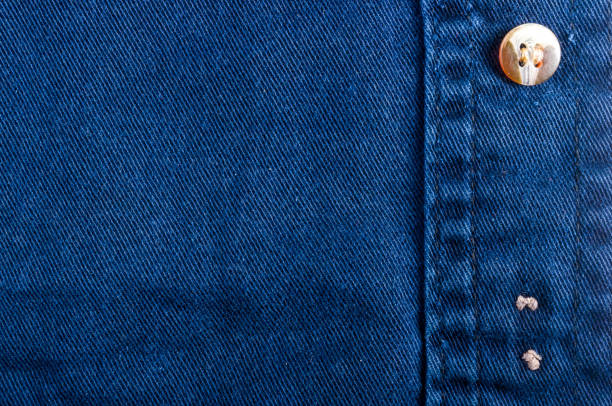 istock clothing items stonewashed cotton fabric texture with seams, clasps, buttons and rivets, macro 1153316447