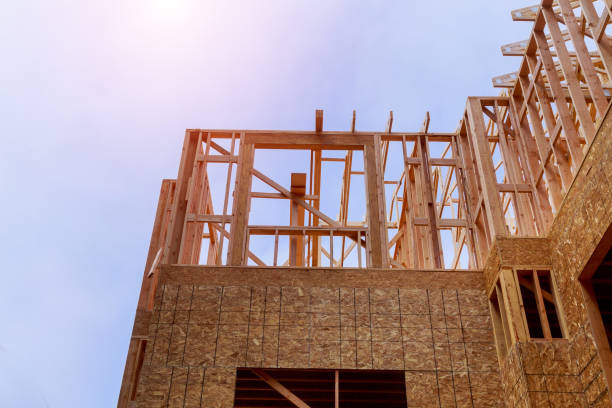 istock Looking up new construction beams under a clear blue sky with sunlight 1153331621