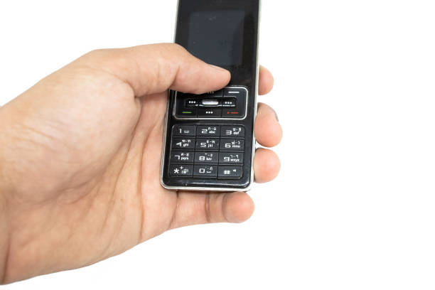 istock Finger holding old generation of mobile phone with white isolate die cut background. Traditional cellphone during 1995-2010 century. 1153335269