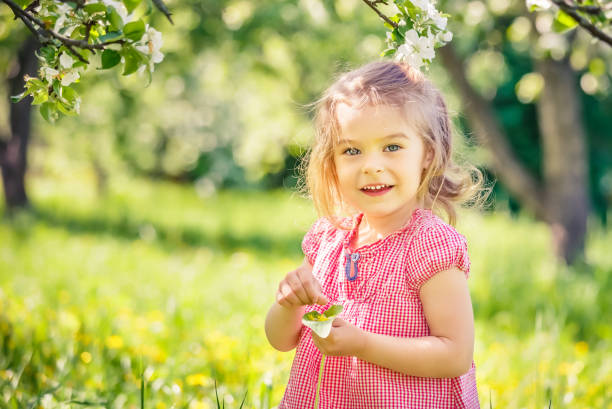istock Happy little girl in spring sunny park 1153335941