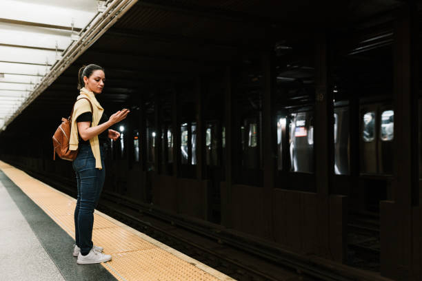 istock Woman in the subway with cellphone in hand 1153336290