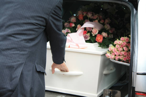 White coffin in a grey hearse A funeral home employee takes out a white coffin of a hearse funeral parlor photos stock pictures, royalty-free photos & images