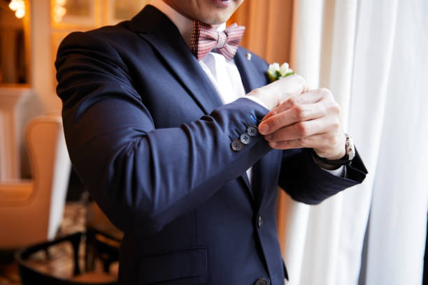 le marié prend soin des derniers détails avant le mariage. mettre des boutons de manchette. - homosexual wedding married engagement photos et images de collection