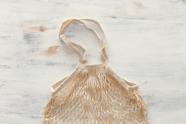istock white mesh shopping bag over white wooden background. top view flat lay 1153349601