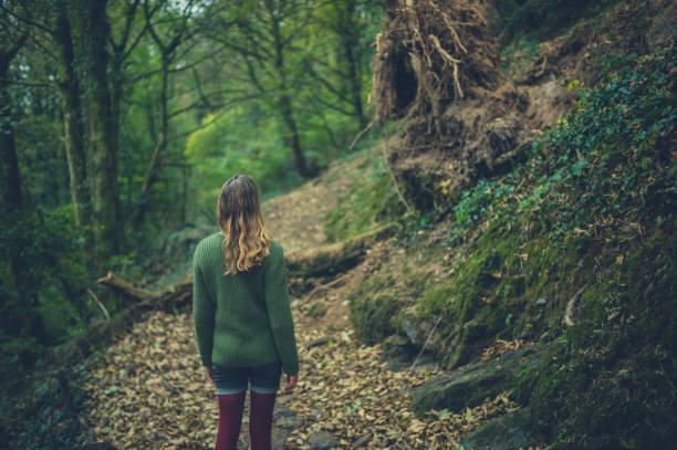 istock Young woman walking in the woods 1153351898