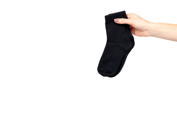 istock Hand with black cotton sock, foot clothing. 1153357843
