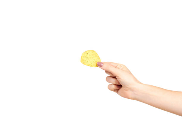 Hand with golden color potato chips, crunchy and wavy.