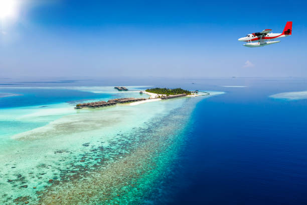 A seaplane approaching a tropical island in the Maldives