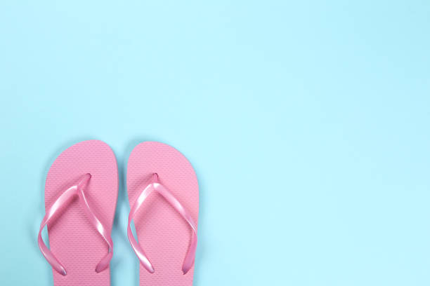 istock Pair of flip flops on blue background 1153361106