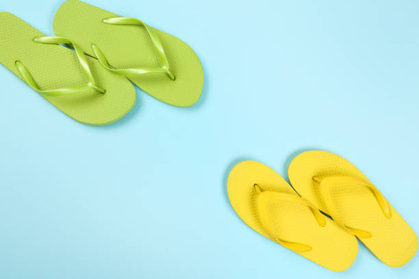 istock Pair of flip flops on blue background 1153361246