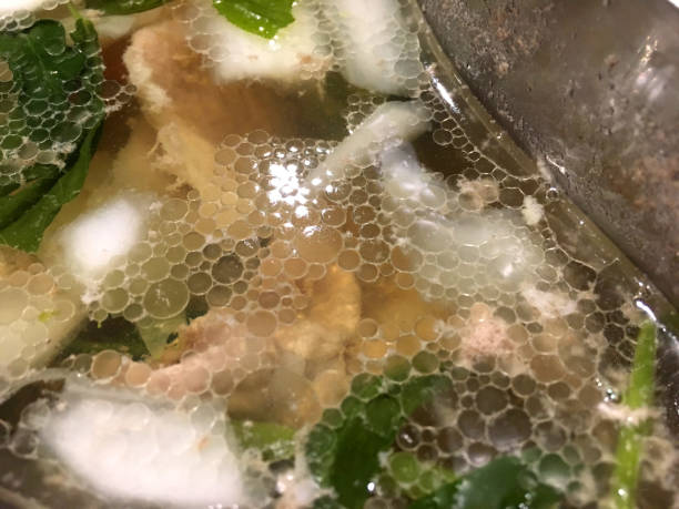 istock Fat bubbles floating on Shabu soup with pork, white and green vegetable. 1153366085