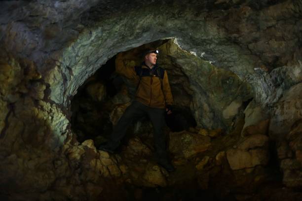 istock Man looks around, standing in a karst cave 1153368431