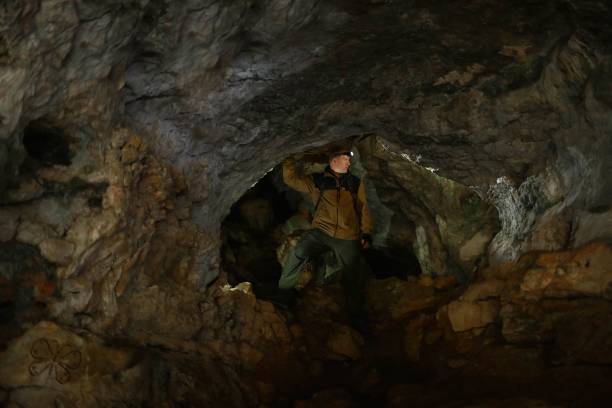 istock Man looks around, standing in a karst cave 1153368436