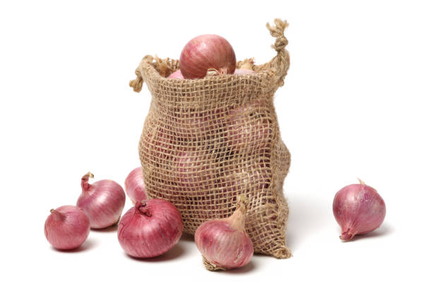 onion bulbs in a kraft paper bag on a wooden table