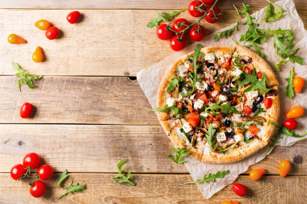 istock Vegetable italian pizza with tomatos on wodeen background 1153371011