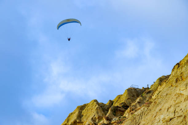Man doing sport (Para-glider). Man paragliding in the clouded sky. Paragliding is an extreme sport and recreation. Torrey Pines Glider port. San Diego. California, USA.