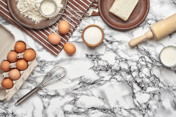 istock Close-up shot. Top view of a baking ingredients and kitchenware on the marble table background. 1153380970