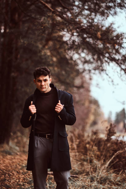 istock A handsome stylish young man posing in the autumn forest. 1153382914