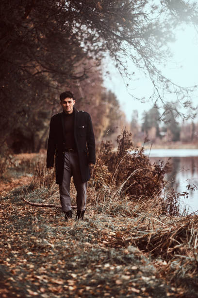 istock A handsome young man walking in the autumn forest. 1153382993