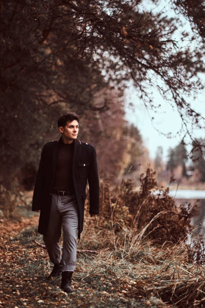 istock A handsome young man walking in the autumn forest. 1153383229