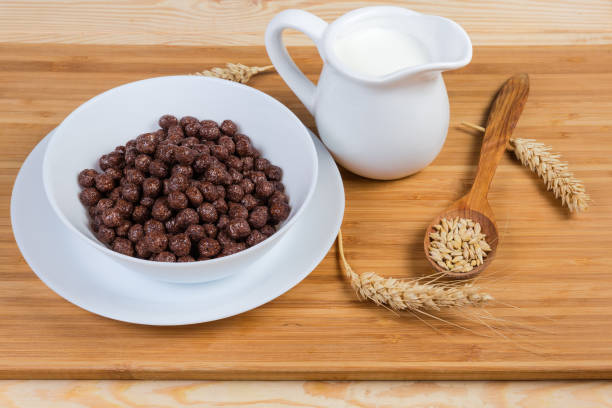 istock Breakfast cereal chocolate balls and milk among ears and grains 1153383661
