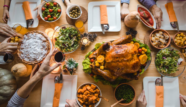 istock Above view of unrecognizable people having Thanksgiving dinner at the table. 1153385181