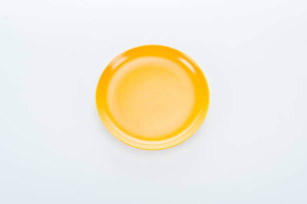 istock top view of shiny empty yellow plate on white background 1153386083