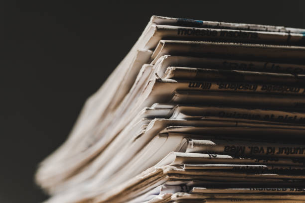 istock different print newspapers in pile isolated on black 1153386133