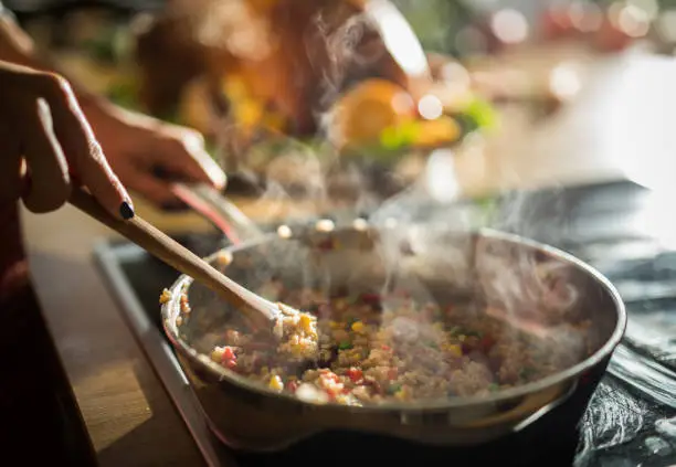 Photo of Close up of unrecognizable woman preparing lunch in the kitchen.