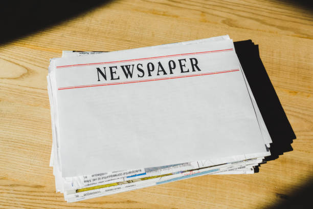 istock pile of newspapers with copy space on wooden table 1153386537