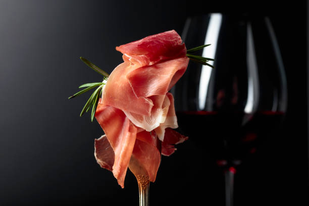 istock Prosciutto with rosemary and red wine on a dark background. 1153387919