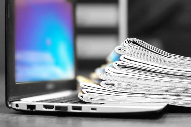Laptop and Newspapers stock photo