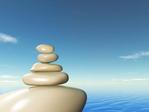 istock 3D balancing pebbles against an ocean landscape 1153390341
