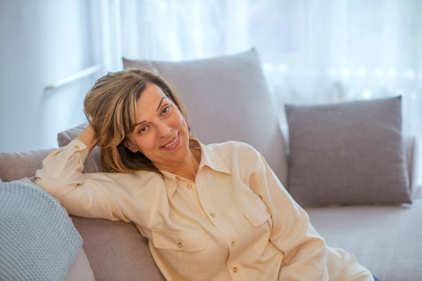 istock Happy senior woman on couch 1153392688