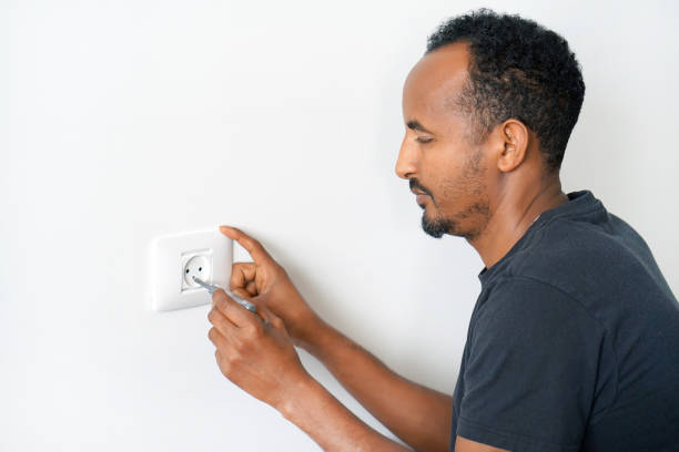 istock An electrician checks the voltage in the wall socket. 1153395686