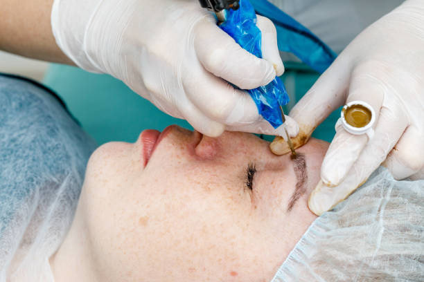 istock Permanent makeup, tattooing of eyebrows. Cosmetologist applying make up 1153397547