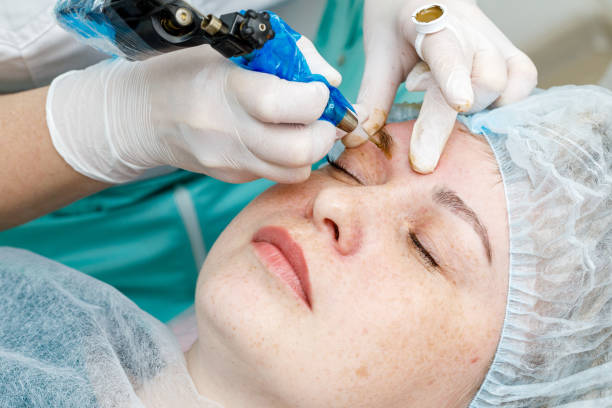 istock Permanent makeup, tattooing of eyebrows. Cosmetologist applying make up 1153397556