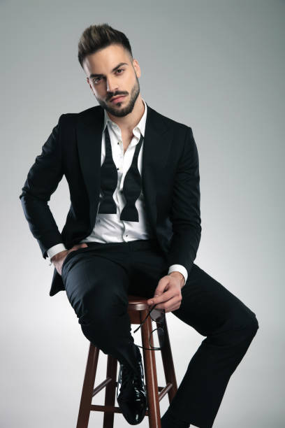 istock Attractive guy sitting and holding his glasses 1153398581