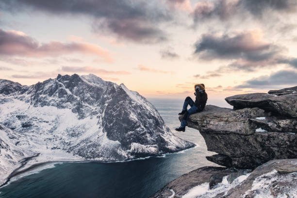 istock Man climber sitting on ridge rock with sightseeing snow mountain on ryten mount 1153401886