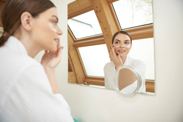 istock Smiling young lady carefully touching eye patch on her face 1153407856