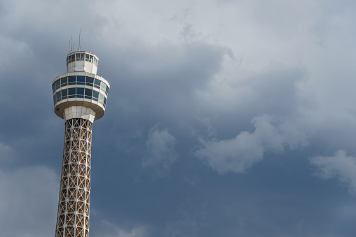 Yokohama, Japan - April 2, 2019: Yokohama Maritime Tower rises in the clouds. Completed in 1961, it's one of the tallest lighthouse in the world