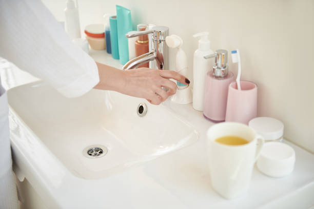 istock Cosmetics on the sink and hand taking brush 1153407926
