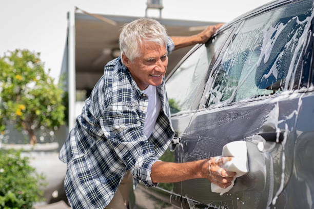 istock Smiling man washing his car 1153408352