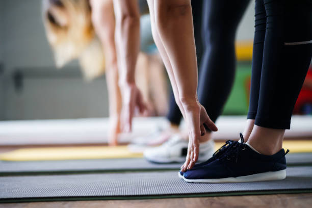 istock Women hands stretching to toecaps, group workout 1153409685