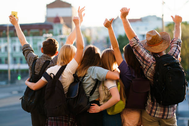 friends tourists with backpacks rising hands